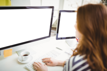 Rear view of businesswoman working on computer