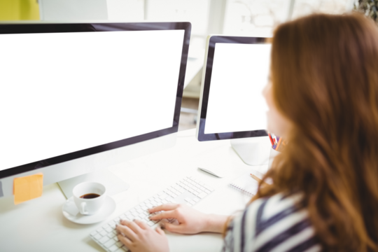 Rear view of businesswoman working on computer