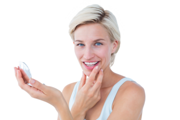 Beautiful blonde looking her skin in the mirror