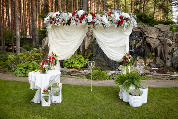 The decor of a romantic wedding ceremony. Wedding arch decorated with flowers