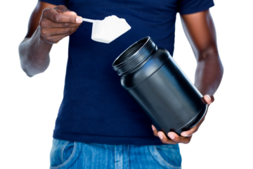 Mid section of man holding a scoop of protein mix