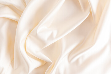 Luxurious satin fabric with delicate waves of beige color. wedding fabric background.