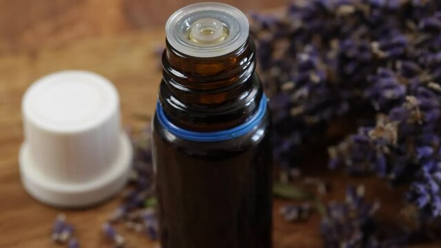 bouquet de lavande s&eacute;ch&eacute;e et Flacons verre d'huile essentielle, en gros plan, sur une table