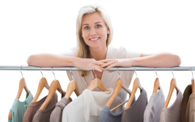 Pretty blonde smiling at camera by clothes rail