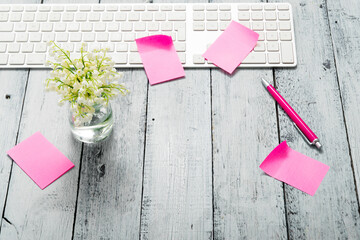 loft style place of work with lily of the valley and pink post its