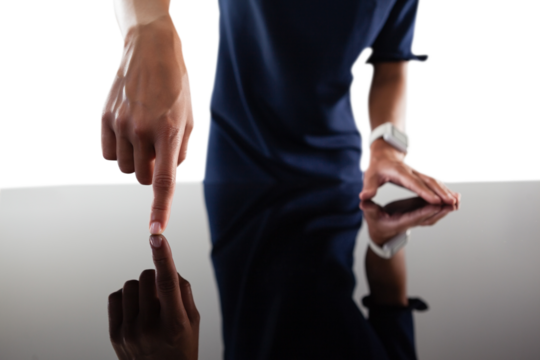 Businesswoman touching invisible screen on glass table