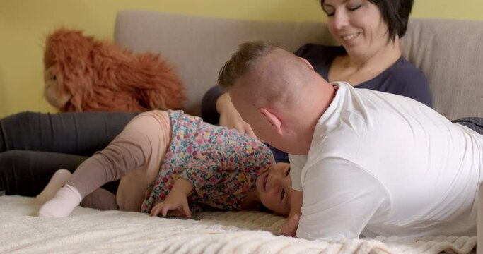 Portrait of family playing with child, lifestyle indoors Providing support to limbless and injured veterans for life. Women who have suffered life-changing limb loss in honorable service of country. 