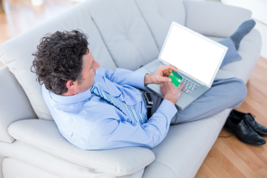 Businessman doing online shopping on couch - Powered by Adobe