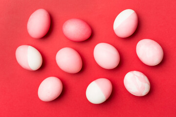 Pink Easter eggs with decor on color background, top view