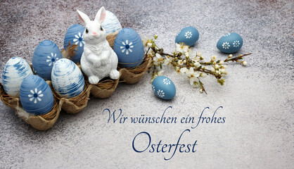 Grußkarte Frohe Ostern: Blaue Ostereier und ein Dekohase mit dem Ostergruß wir wünschen ein...