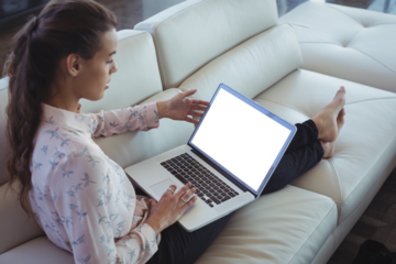 Businesswoman using laptop while resting on sofa