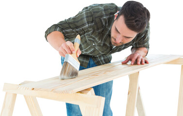 Worker using brush on wooden plank