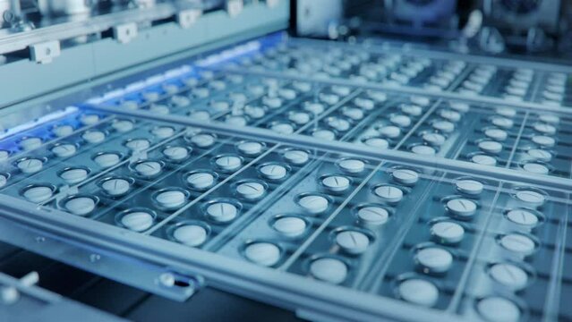 Medicinal Drug Manufacturing. Close-up Shot of White Pills During Production and Packing Process on Modern Pharmaceutical Factory. 