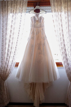 abito da sposa appeso in un a finestra