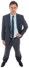 Stern businessman standing with hand on hip