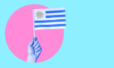 A collage of modern art. Female hand holding the flag of Uruguay in a circle, neon background, with space for text.