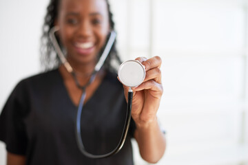 Close up of doctor's stethoscope with smiling female doctor in background