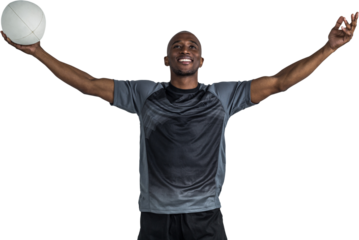 Confident athlete with arms raised holding rugby ball