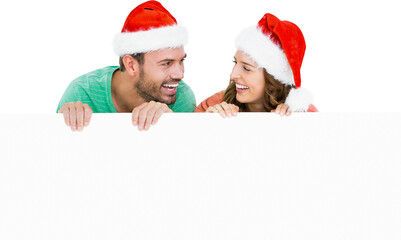 Happy young couple wearing santa hat