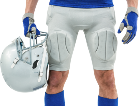 Midsection of American football player holding helmet