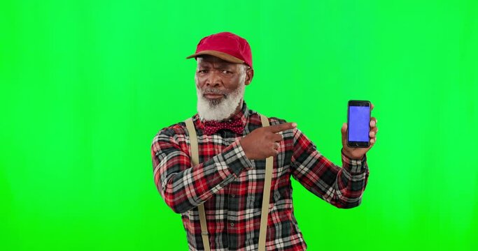 Dancing, phone and senior black man pointing, showing and advertising cellphone screen isolated in a green screen studio background. Excited, funny and portrait of a goofy old person in with mockup