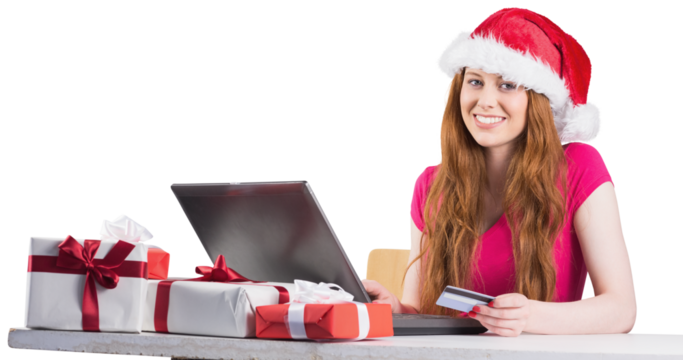 Festive redhead shopping online with laptop