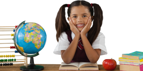 Schoolgirl leaning by globe and books