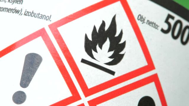 Dangerous flammable corrosive substance bottle packaging, red warning signs, customer safety, security, damaging chemical substance symbols, object detail, extreme closeup, nobody. Chemicals bottle