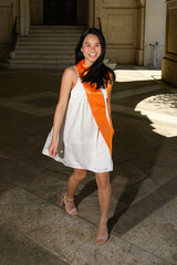 Young attractive Asian American girl posing for graduation photos from a university