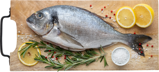 Dorado fish with lemon slices, salt and rosemary on cutting board. Top view, flat lay, isolated.