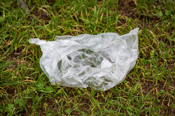 White plastic bag thrown in the forest, Environmental damage.Plastic waste left in forest. Concept of plastic pollution