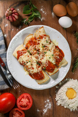 pancake with tomato sauce topped with chicken and cottage cheese with a pile of wheat farinah topped with an egg, tomatoes, herbs and garlic on the side