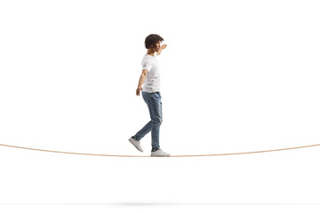 Full length profile shot of a young african american man walking on a tightrope and keeping balance