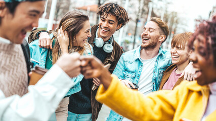 Multiracial young friends having fun walking on city street - University students laughing together outside college - Life style concept with guys and girls hanging out