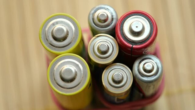 A bunch of generic old rechargeable alkaline batteries of different sizes, group of objects up close macro extreme closeup, energy storage, power, safe battery waste disposal, recycling simple concept