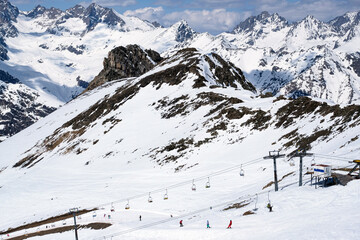 Snowboarders skate on the slope of the mountain. Against the background of beautiful mountains