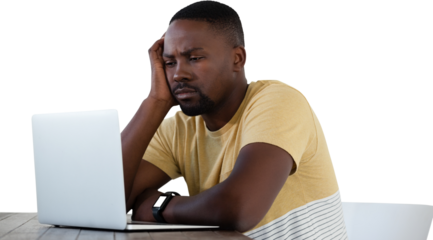 Sad young man looking into laptop
