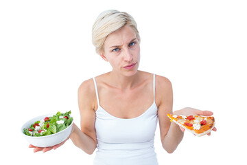 Pretty woman deciding between pizza and salad