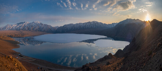 Panorama of a mountain lake with floating ice and icebergs at sunset. View from the top of...
