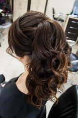 Photo of a stylish female vintage hairstyle, Greek braid, on the back of the girl's head. Image for your creative decoration or design.