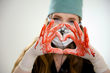 Operation and medicine theme Bloody hand surgeon holding a human heart in a bloody white gloves...