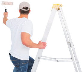 Handyman climbing ladder while using paint roller