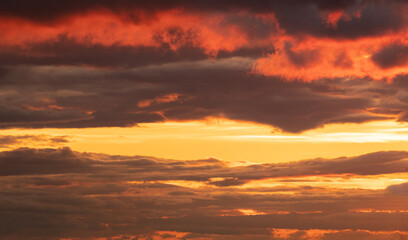 Naklejka na ściany i meble Beautiful bright orange sunset sky with dramatic clouds. Sunset sky with clouds background.