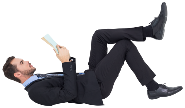 Businessman lying on the floor while reading a book
