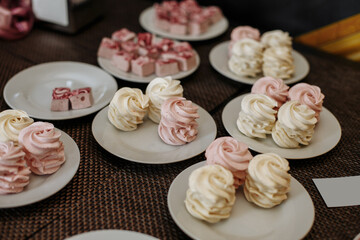 White and pink marshmallows on white plates