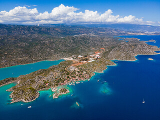 Aerial drone shot of Simena Castle (Kalek&ouml;y), beach, and yachts, displaying the historic site and enchanting Mediterranean landscape in Antalya, Turkey.