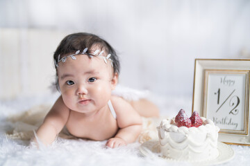 明るい自然光でハーフバースデーをお祝いする生後6か月の天使の赤ちゃん