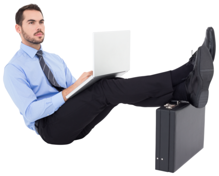 Businessman sitting on the floor with feet up on suitcase