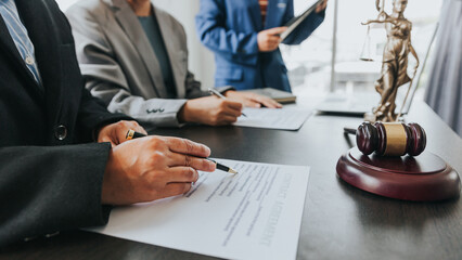 Close up of female lawyer writing contract with Judge Havel Brass scale on a table at a law firm...