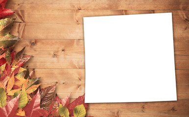 Autumn leaves with blank page on table 
